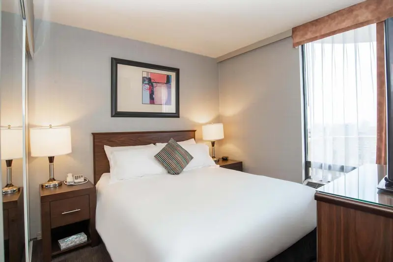 Une chambre d'hôtel avec un grand lit et deux tables de chevet.