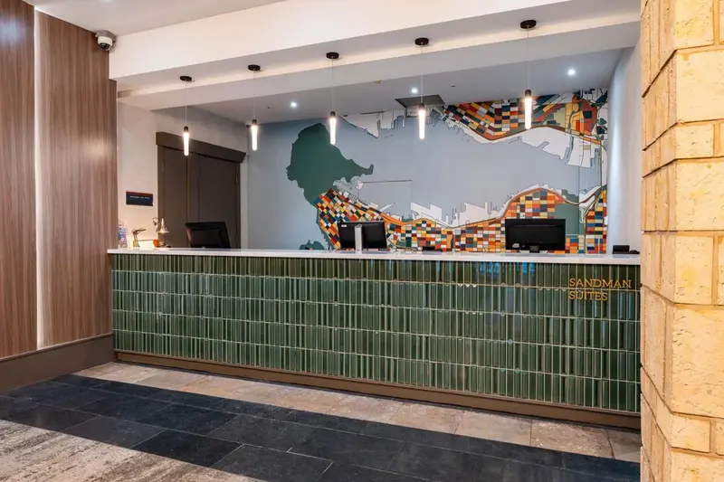 Un comptoir d'accueil moderne avec un mur décoratif coloré.