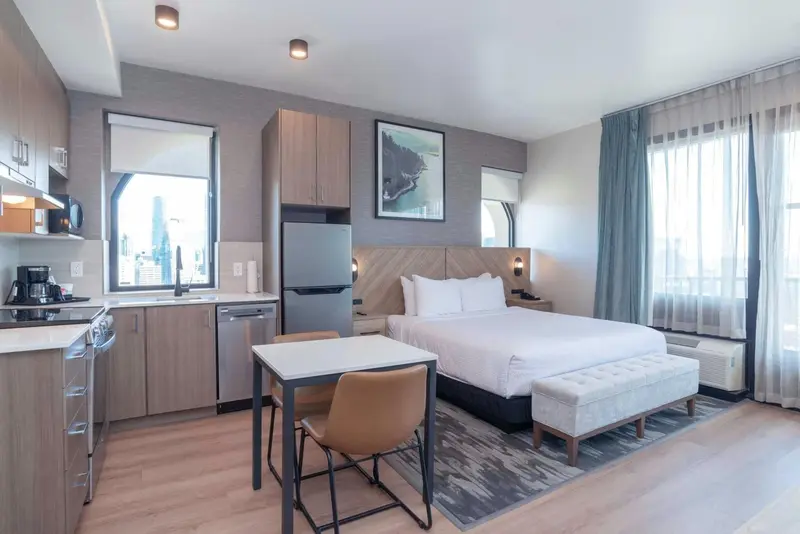 Une chambre lumineuse avec un coin cuisine et un espace repas.
