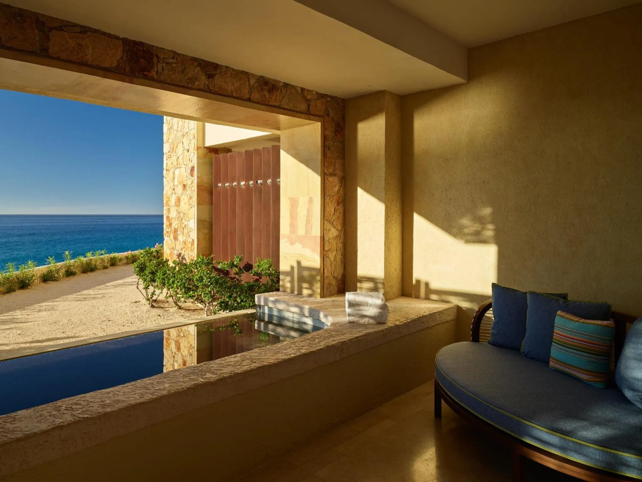 Espace de détente intérieur avec vue sur la mer et une petite piscine.
