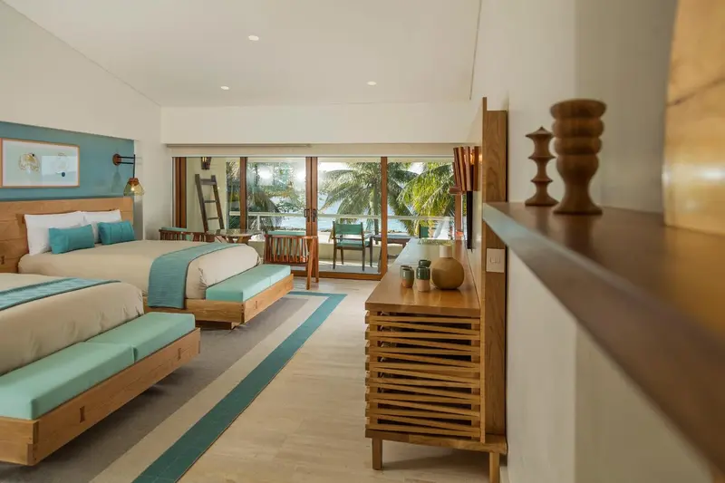 Une chambre lumineuse avec un grand lit et une vue sur la mer.