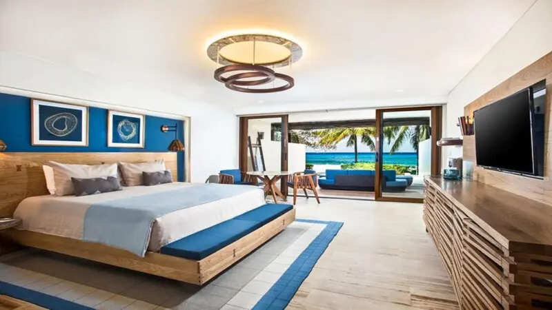 Une chambre lumineuse avec un grand lit et vue sur la mer.