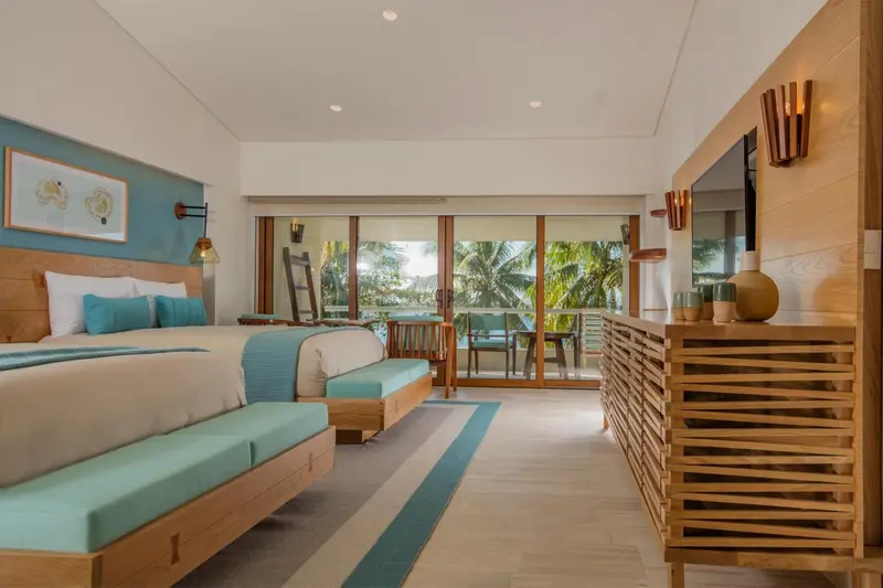 Une chambre lumineuse avec un grand lit et une vue sur la végétation.