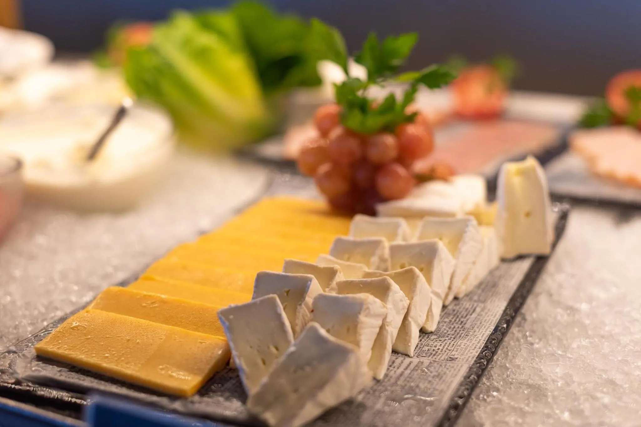 Présentation de fromages et de charcuterie sur un buffet.