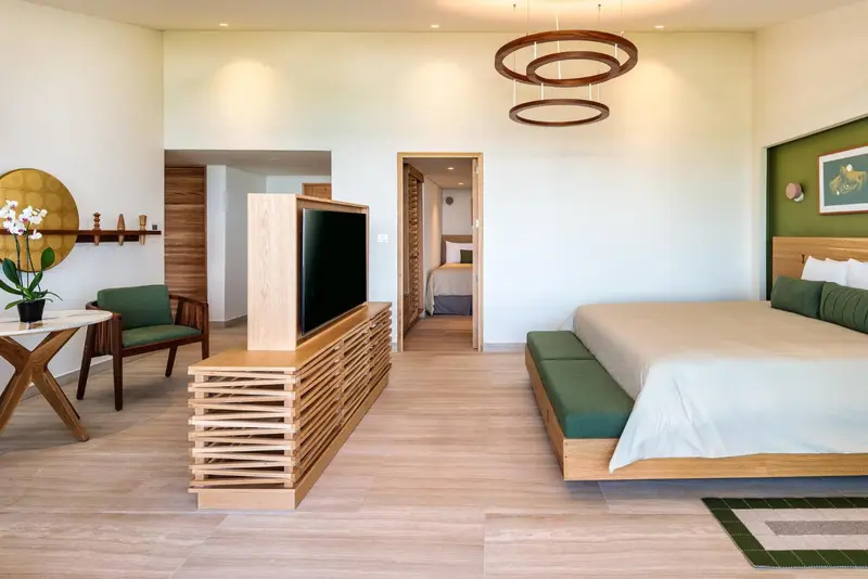 Une chambre lumineuse avec un grand lit et un coin salon.
