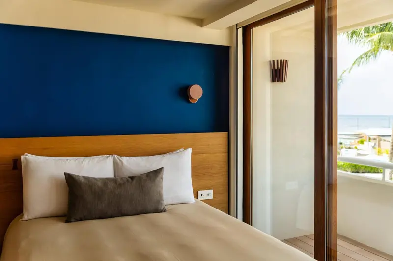 Une chambre lumineuse avec un grand lit et une vue sur la mer.