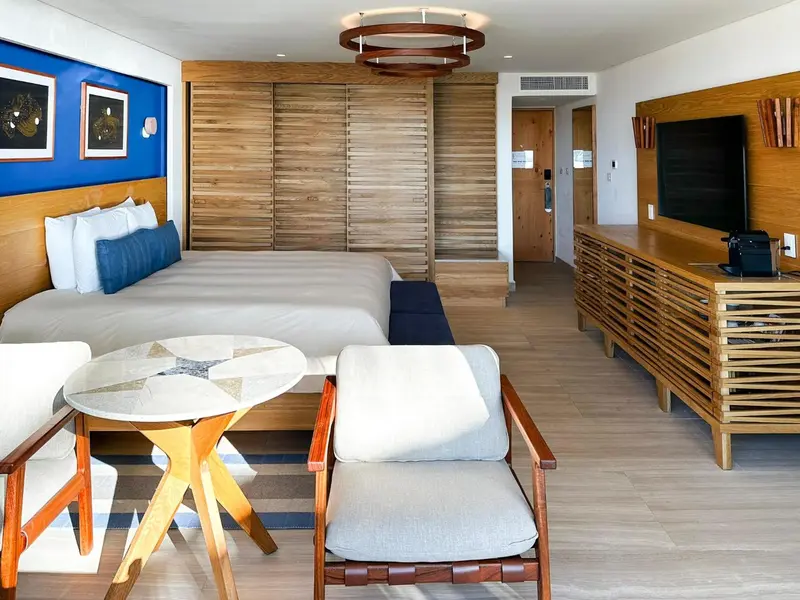 Une chambre lumineuse avec un grand lit et un coin salon.