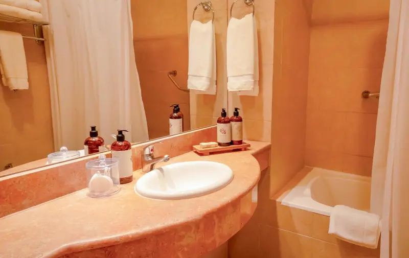 Une salle de bain lumineuse avec lavabo et produits de toilette.
