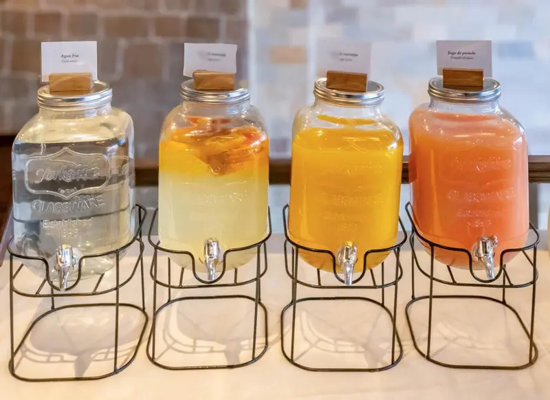Des distributeurs d'eau aromatisée sont alignés sur un comptoir.