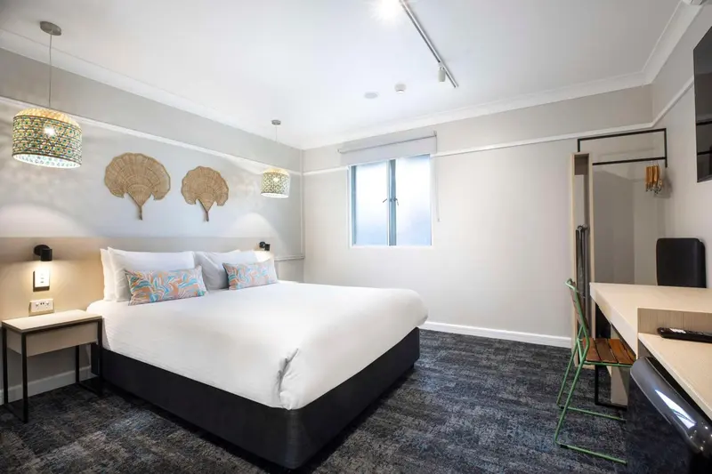 Une chambre d'hôtel lumineuse avec un grand lit et un bureau.