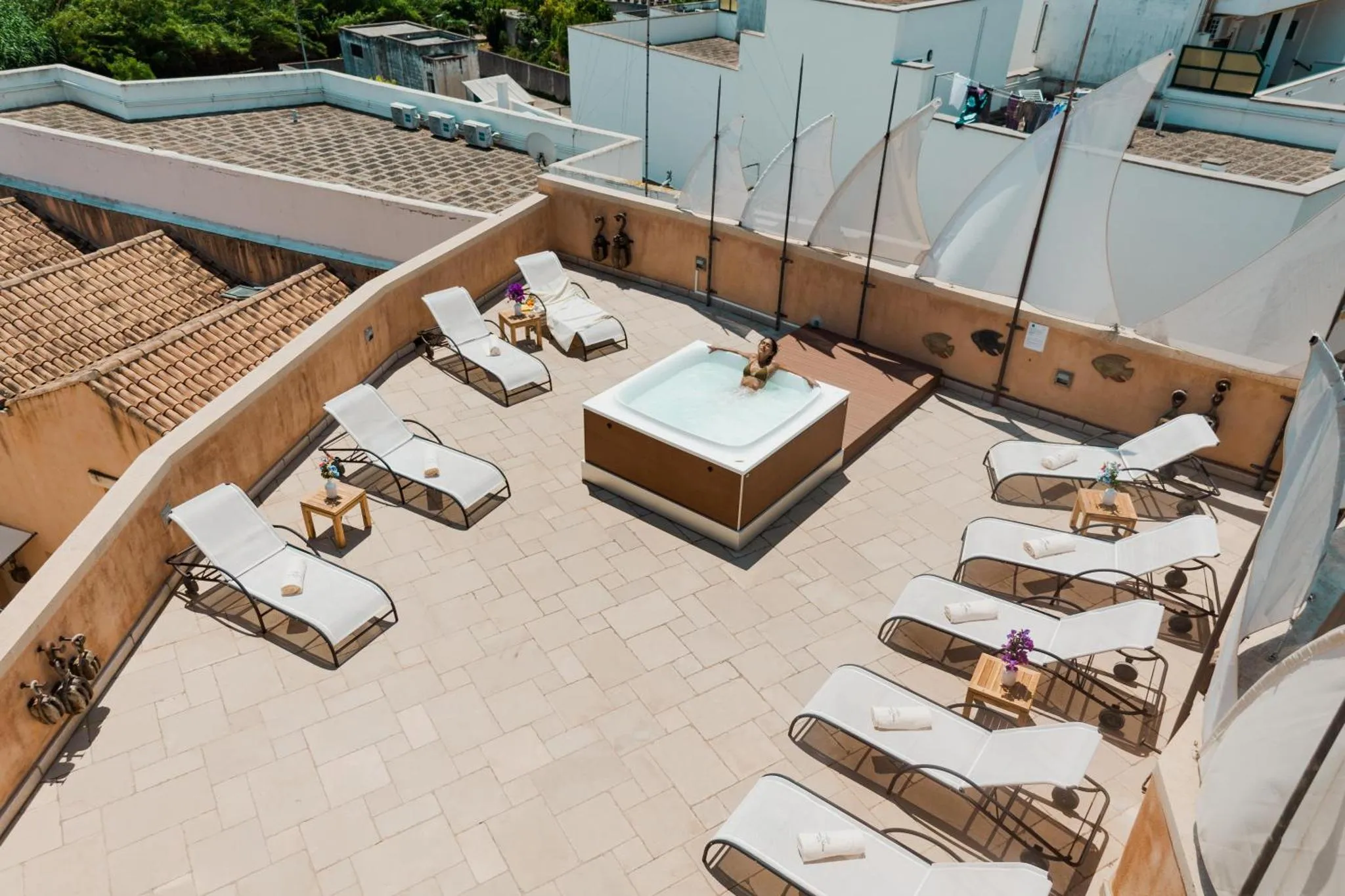 Terrasse aménagée avec transats et jacuzzi.