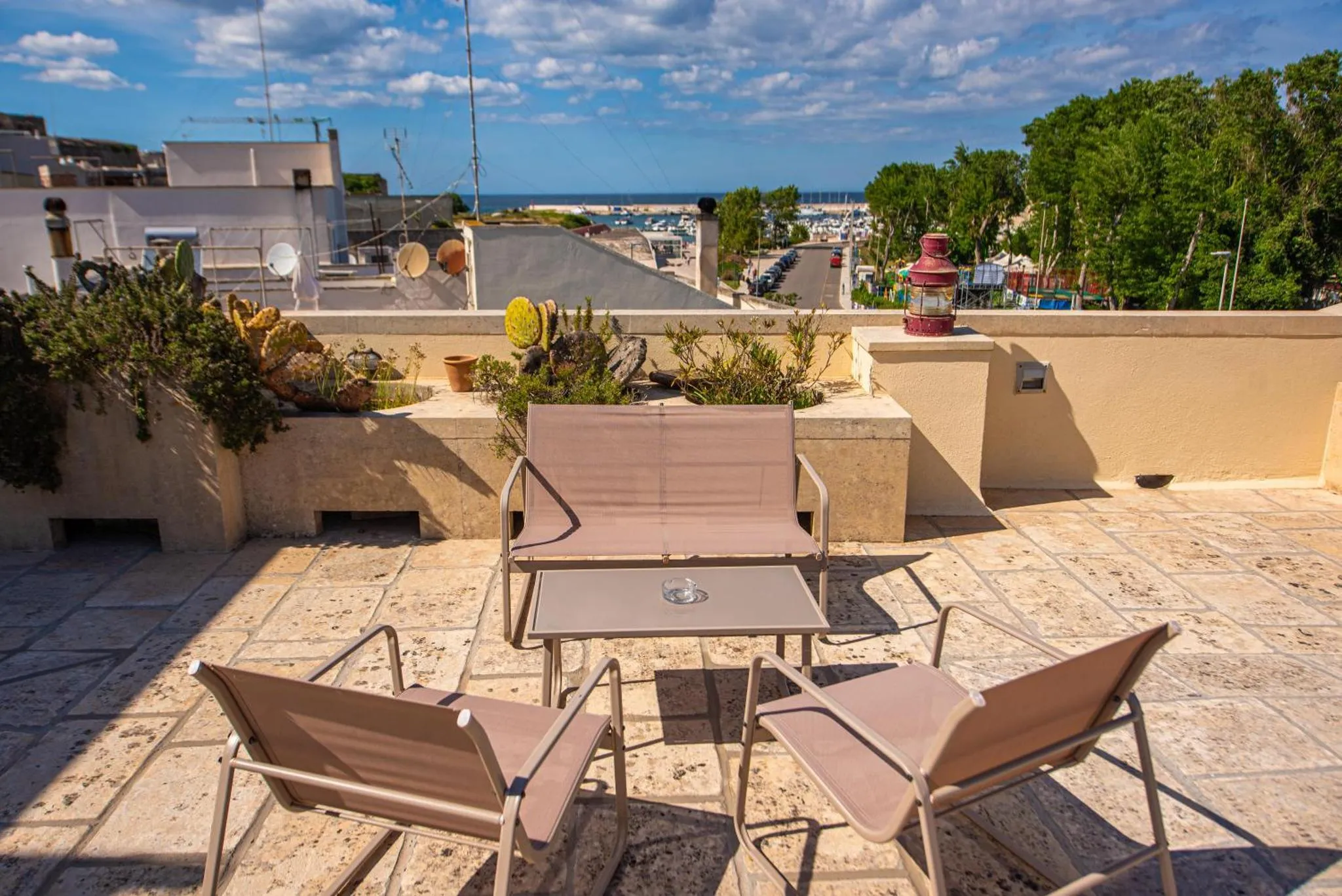 Terrasse aménagée avec mobilier de jardin et vue sur la mer.