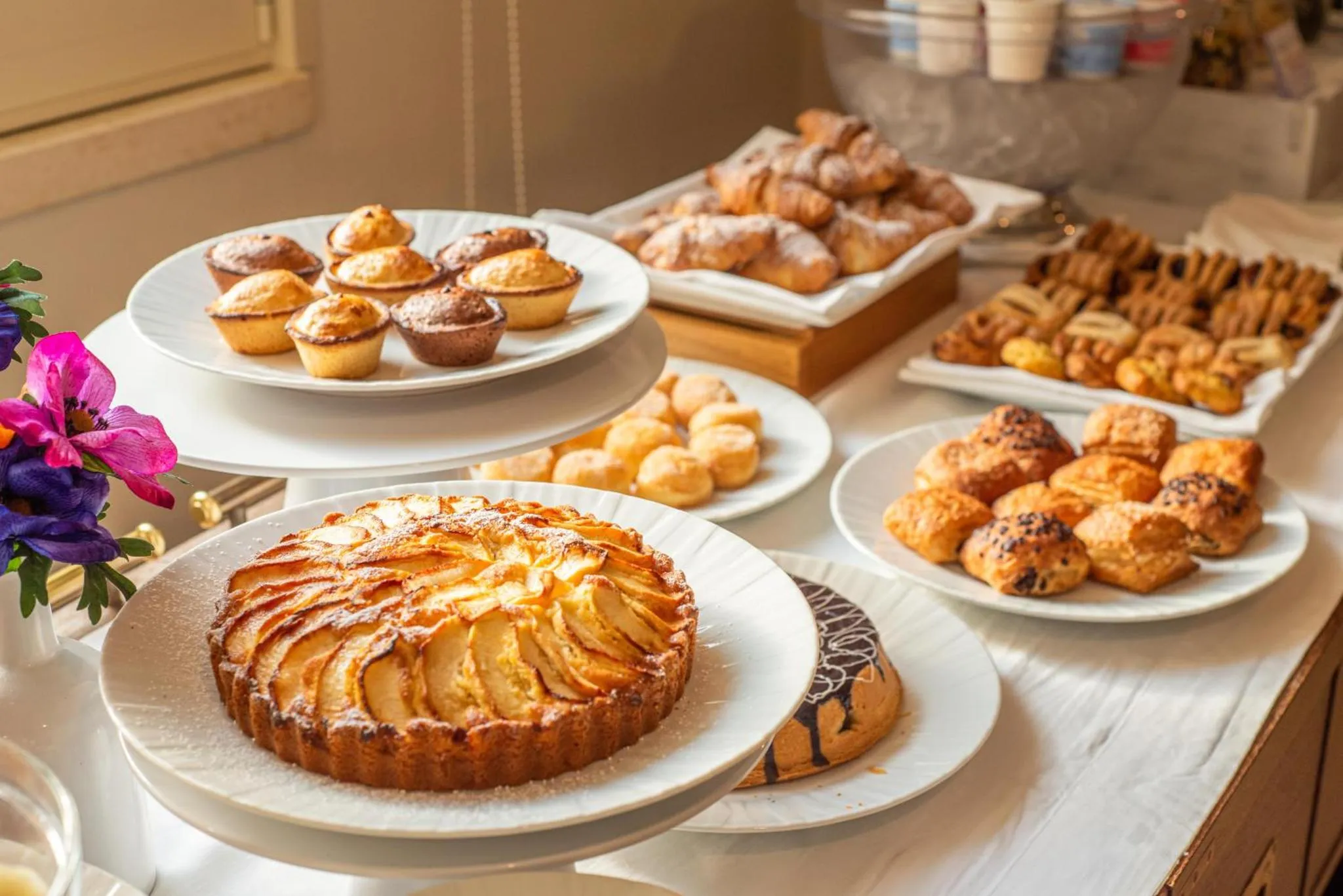 Une table garnie de pâtisseries et de viennoiseries.
