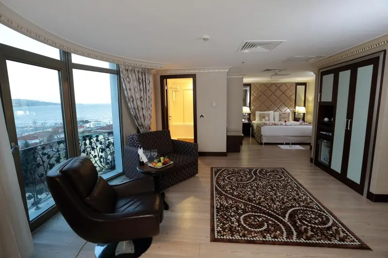 Une chambre spacieuse avec un coin salon et vue sur la mer.