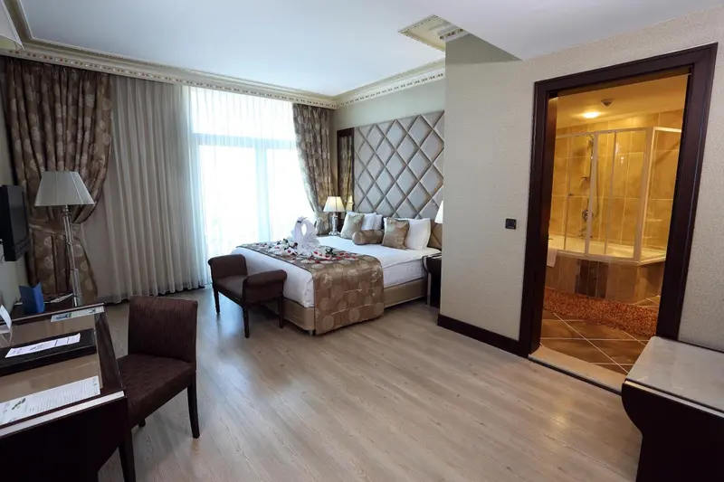 Chambre spacieuse avec un grand lit et une salle de bain attenante.