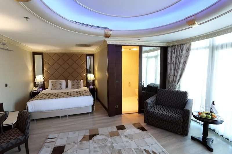 Chambre spacieuse avec un grand lit et un coin salon.