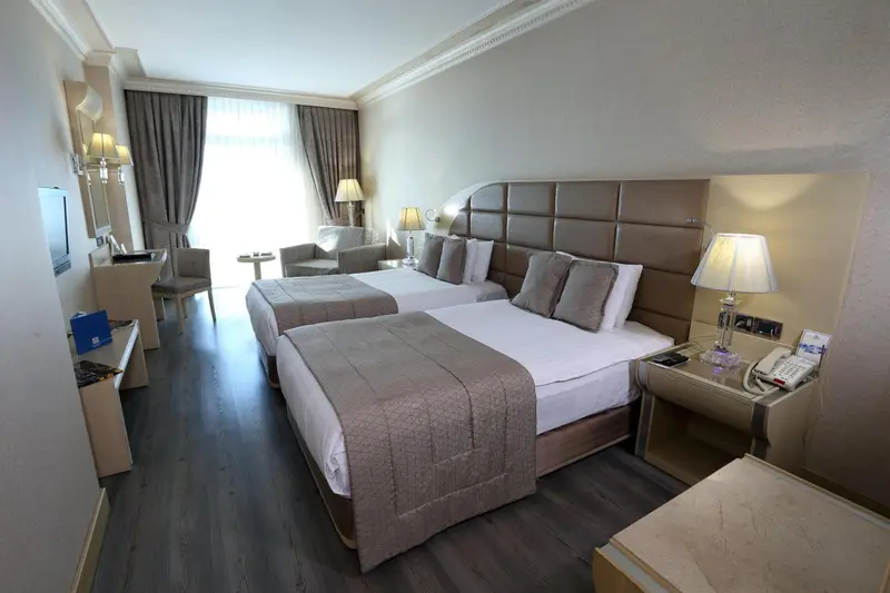 Une chambre d'hôtel lumineuse avec un grand lit et un coin salon.