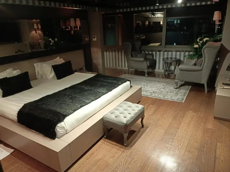 Une chambre spacieuse avec un grand lit et un coin salon.