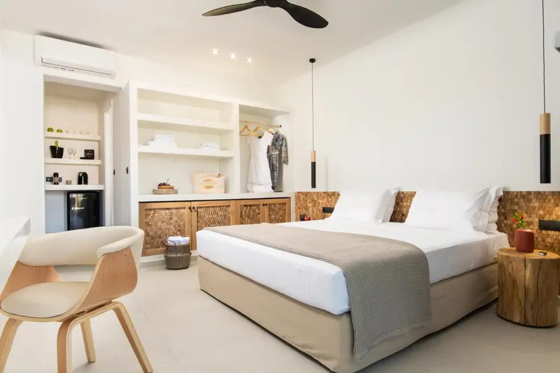 Une chambre lumineuse avec un grand lit et un espace rangement intégré.