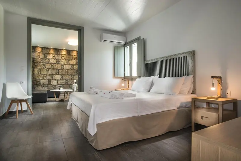 Une chambre lumineuse avec un grand lit et un coin salon.