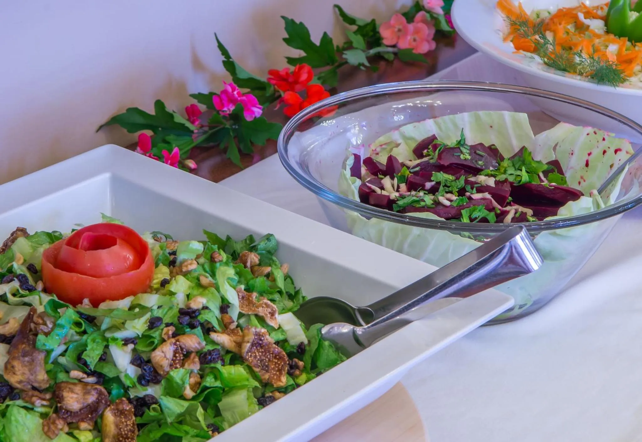 Présentation de salades colorées sur un buffet.