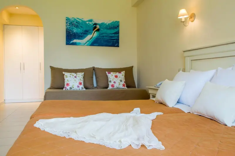 Une chambre lumineuse avec un grand lit et un tableau représentant un plongeur.