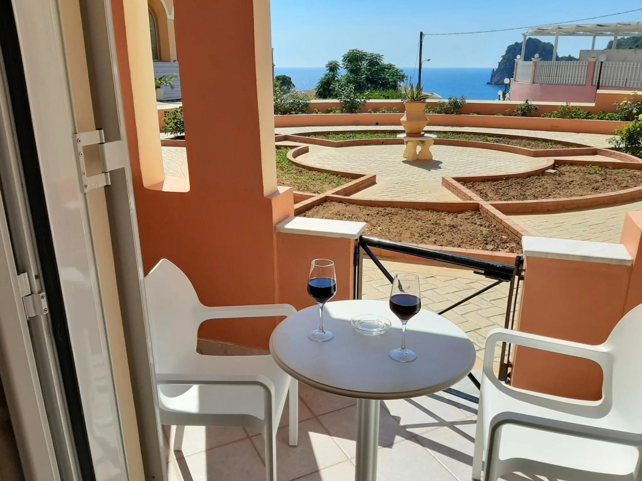 Terrasse avec table et verres de vin donnant sur la mer.