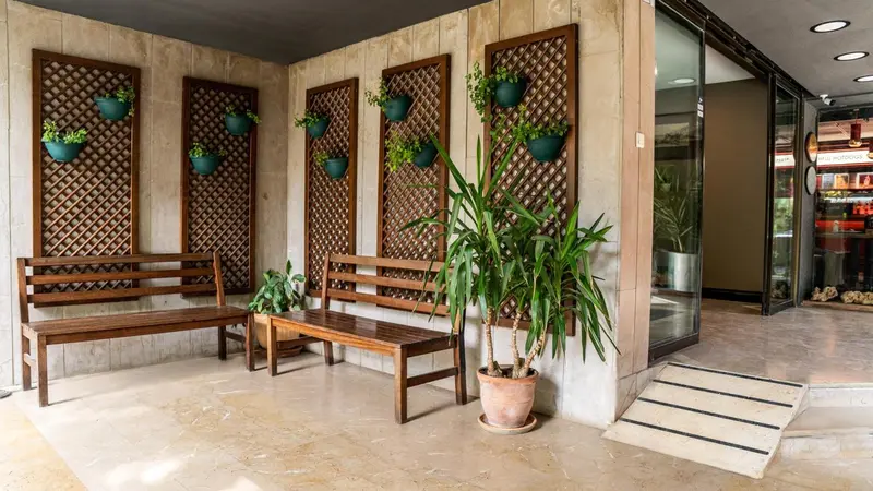 Espace extérieur aménagé avec des bancs et des plantes en pot.