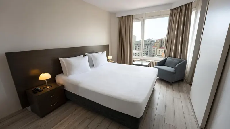 Une chambre d'hôtel moderne avec un grand lit et un fauteuil.