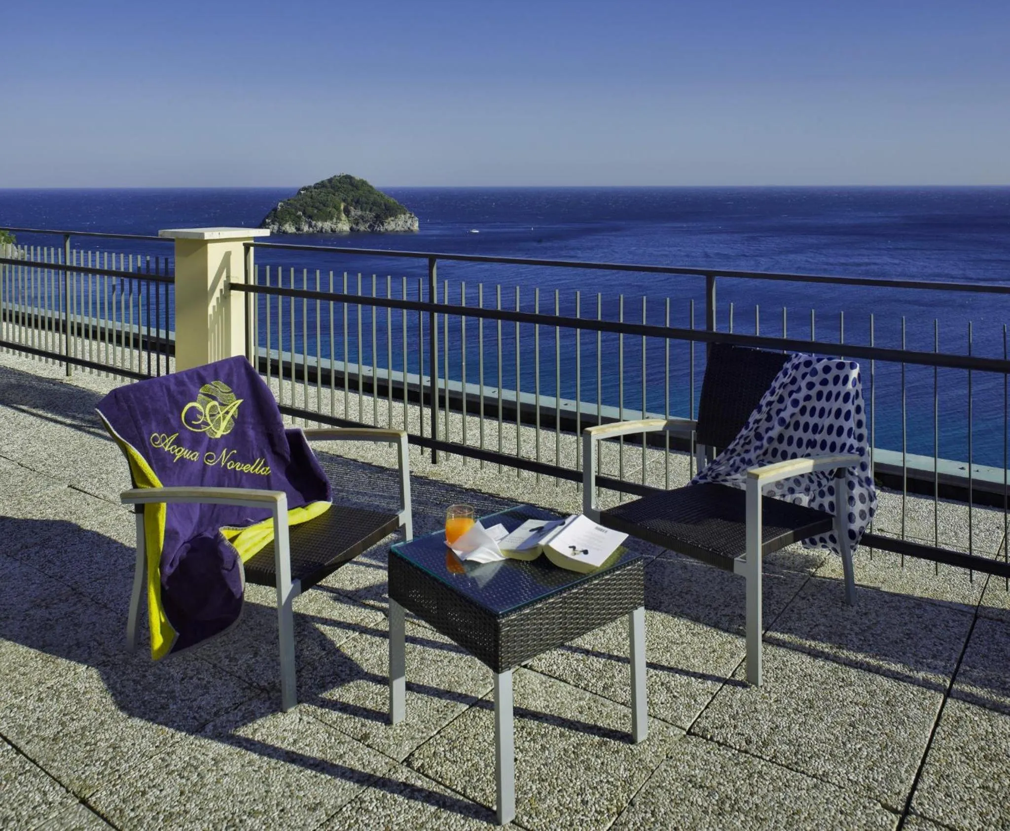Terrasse avec mobilier d'extérieur et vue sur la mer.