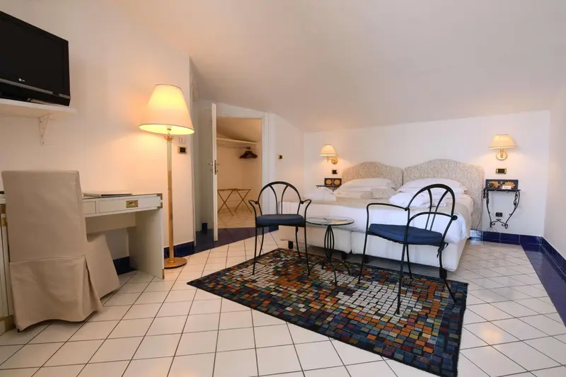 Une chambre lumineuse avec un lit double et un coin bureau.