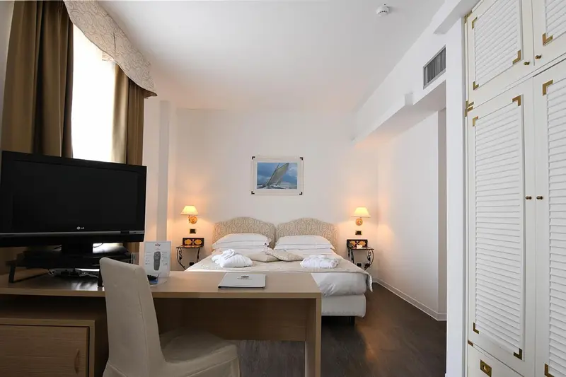 Une chambre d'hôtel lumineuse avec un lit double et un bureau.