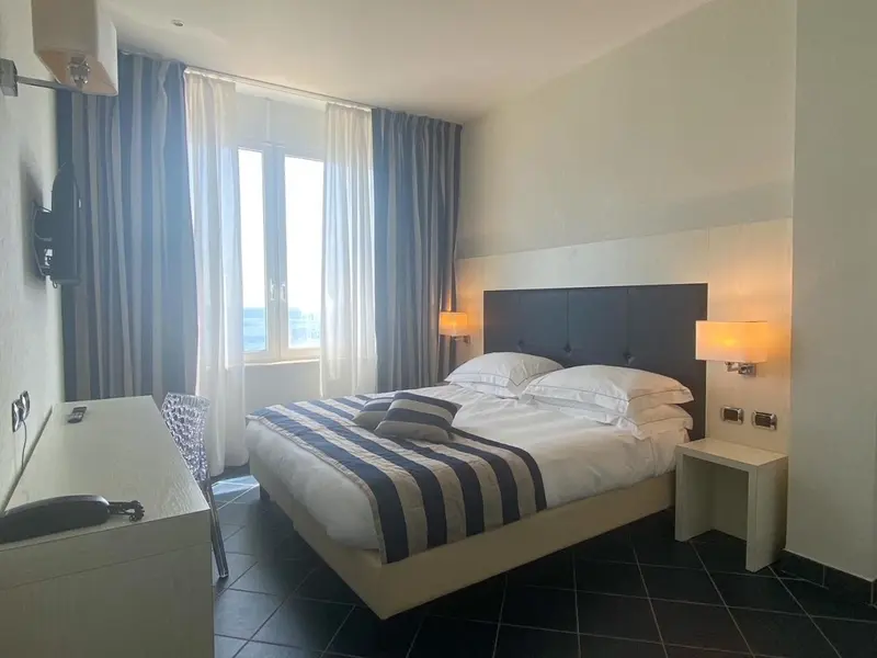 Une chambre lumineuse avec un grand lit et une vue sur la mer.