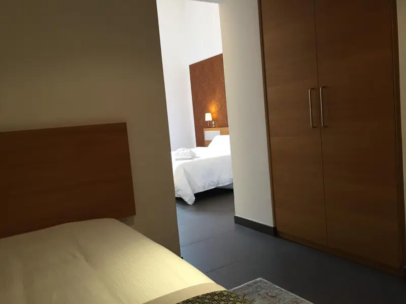 Une chambre lumineuse avec un lit et un placard.