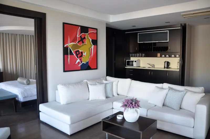 Un salon moderne avec canapé blanc et tableau abstrait rouge.