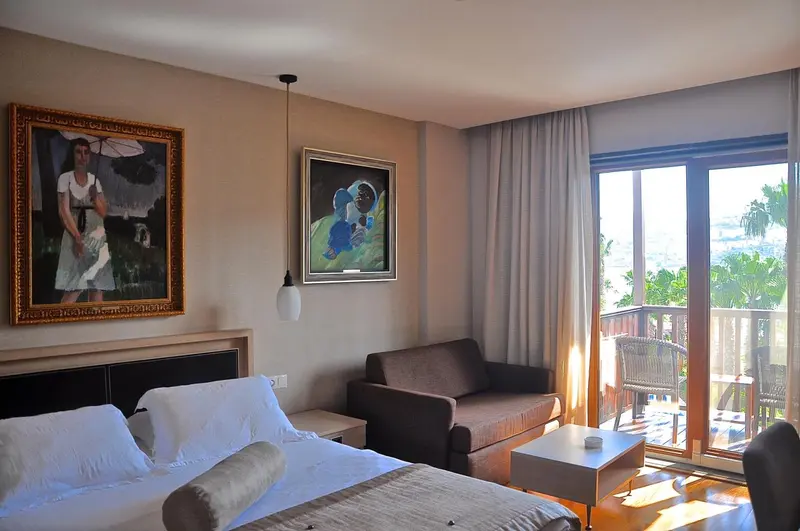 Une chambre lumineuse avec un lit, un canapé et un accès à une terrasse.