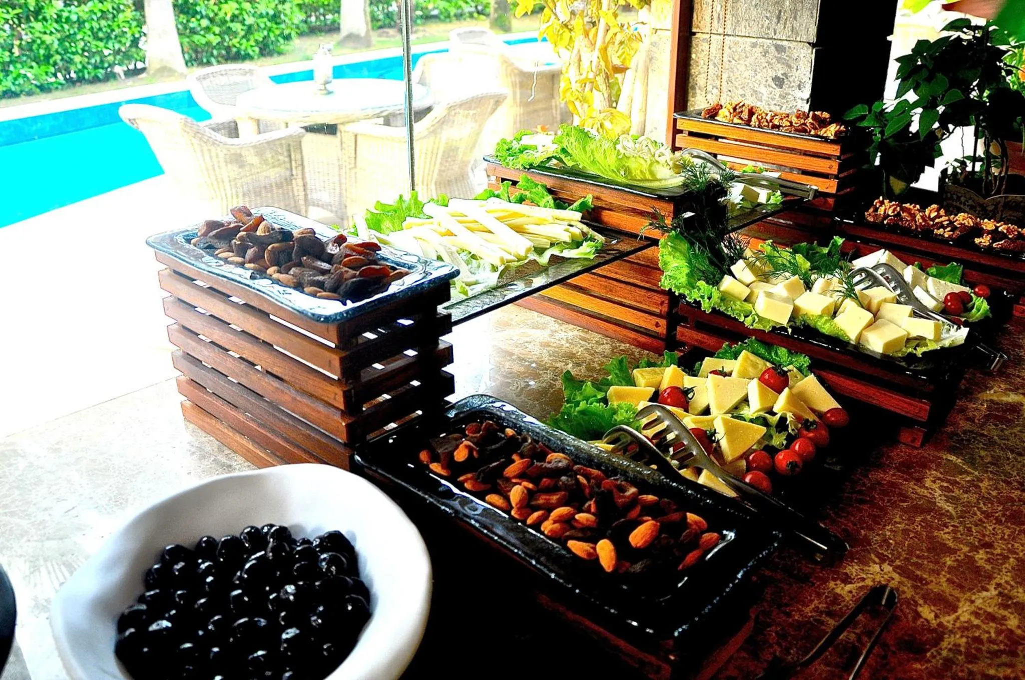 Un buffet propose une variété de salades, de fruits et de pâtisseries.