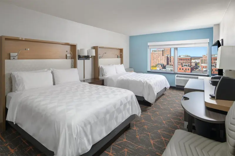 Une chambre d'hôtel avec deux lits doubles et une vue sur la ville.