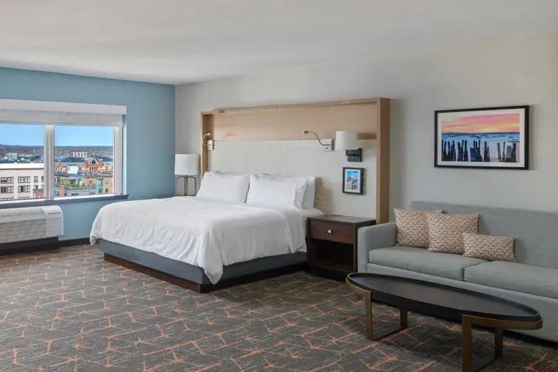 Une chambre lumineuse avec un grand lit et un canapé.