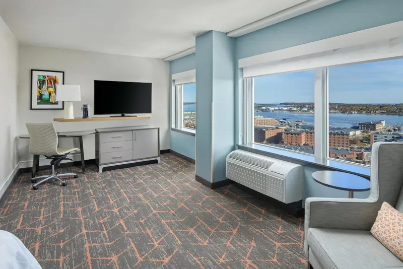 Une chambre lumineuse avec un bureau et une vue sur la mer.