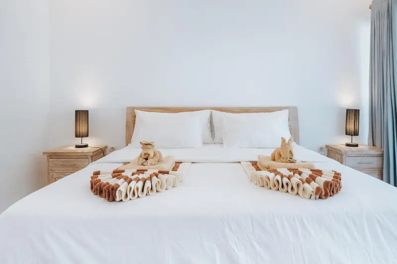 Un lit double est soigneusement fait avec des décorations en serviettes.