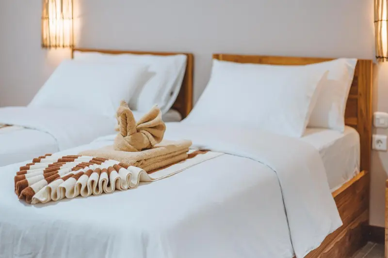Lits préparés avec soin dans une chambre lumineuse.
