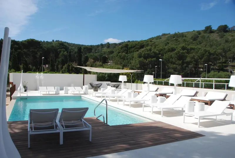 Terrasse avec piscine et chaises longues ensoleillées.