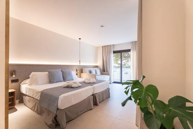 Une chambre lumineuse avec un grand lit et un espace détente.