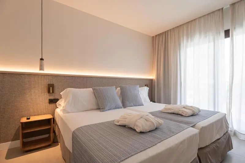 Une chambre lumineuse avec un grand lit et une décoration sobre.