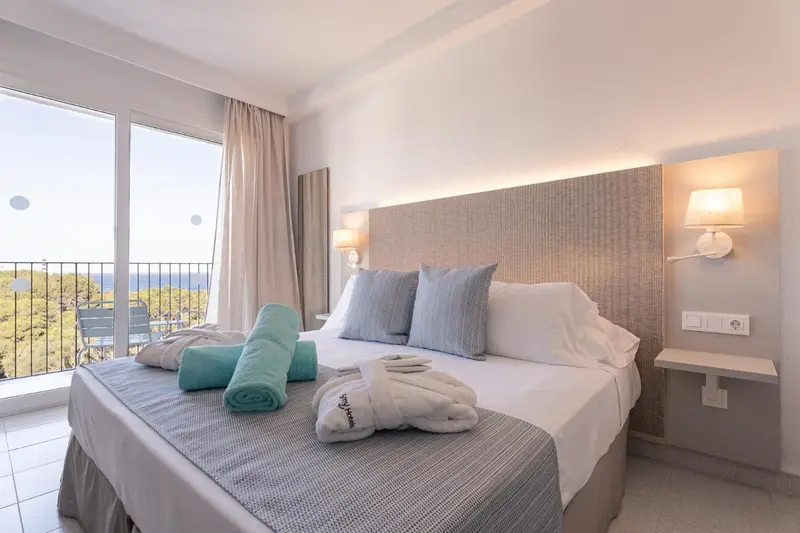 Une chambre lumineuse avec un grand lit et une vue sur la mer.