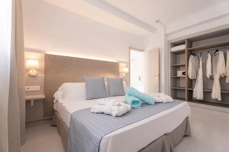 Une chambre lumineuse avec un grand lit et un espace rangement.