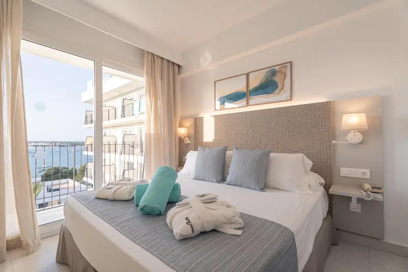 Une chambre lumineuse avec un grand lit et une vue sur la mer.