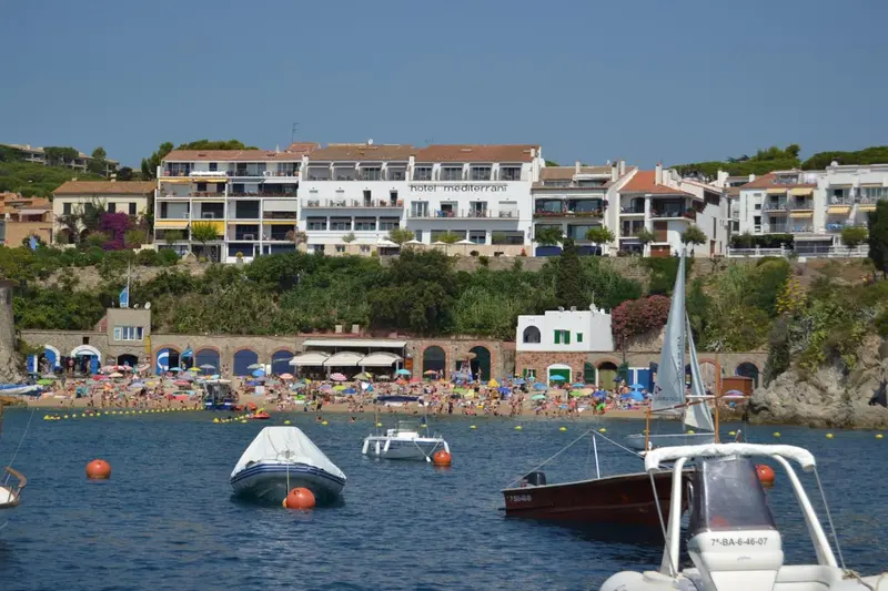 Vue d'une plage ensoleillée avec des bateaux amarrés dans une crique.