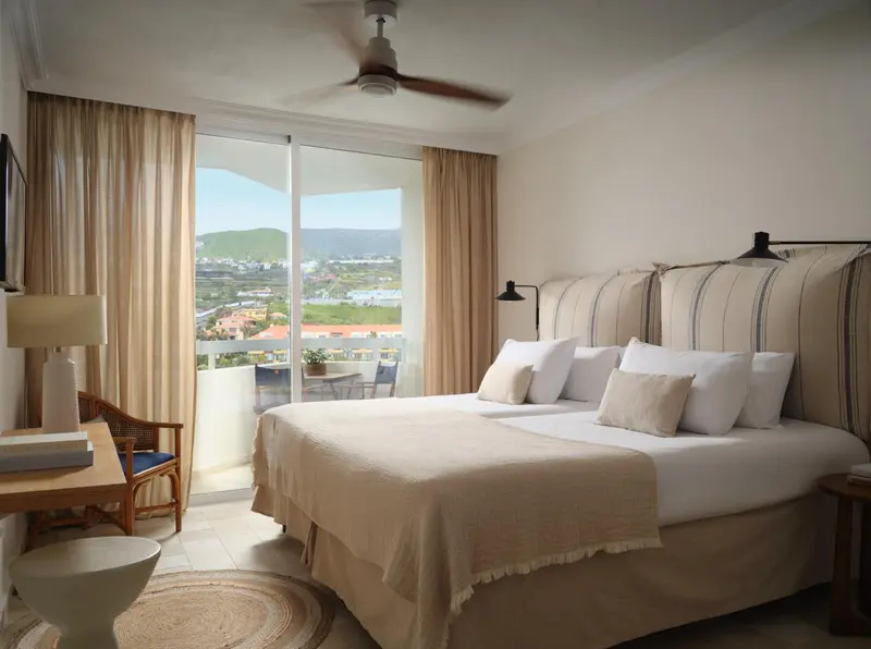 Une chambre lumineuse avec un grand lit et une vue sur le paysage.